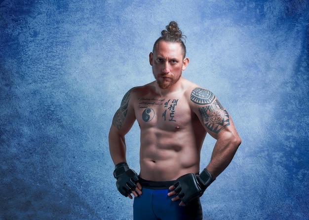 Portrait of a fit young shirtless latin fighter with tattoos isolated on whitex9