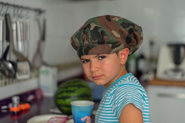 Portrait of a five-year-old boy in the kitchen drinking a glass of milk and with the background out of focus