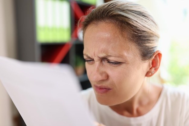 Portrait of focused woman trying read papers squinting to see more clearly female having