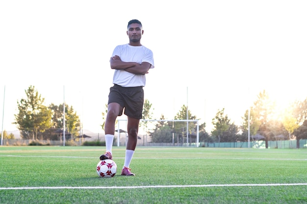 Portrait of football player on the field with his foot on the ball Male football player with his foot on the ball on the grass