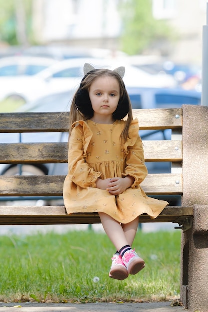 Portrait of a fouryearold girl sitting on a park bench