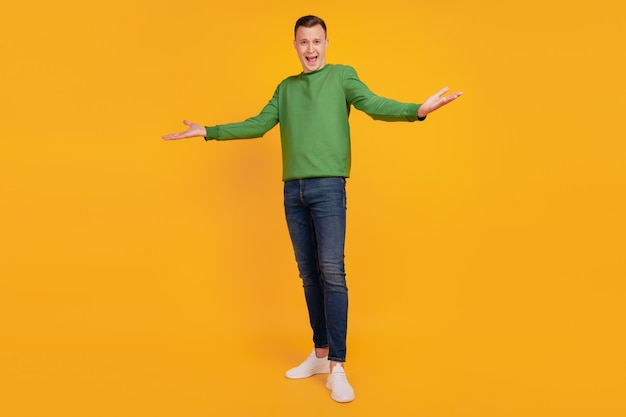 Portrait of friendly charming successful guy open hands posing look camera on yellow background