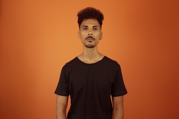 Portrait of a friendlylooking african american man with afro hairstyle smiling isolated on orange copy space