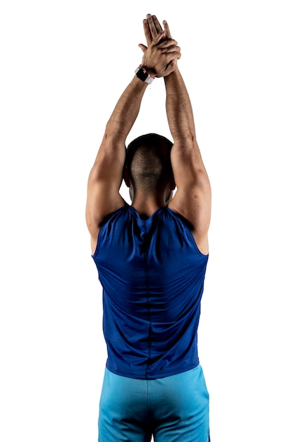 Portrait from behind of a Latino man in blue sportswear stretching his arms