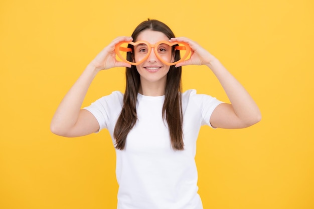 Portrait of a funny girl wearing cool party glasses Cheerful young girl smiling with heartshape