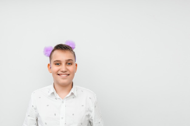 Portrait of a funny guy in a white shirt with purple pompoms on his head