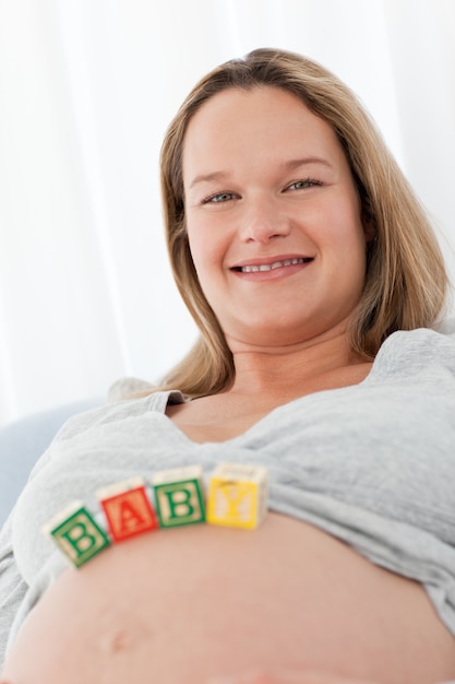 Portrait of a future mom with baby letters on her belly