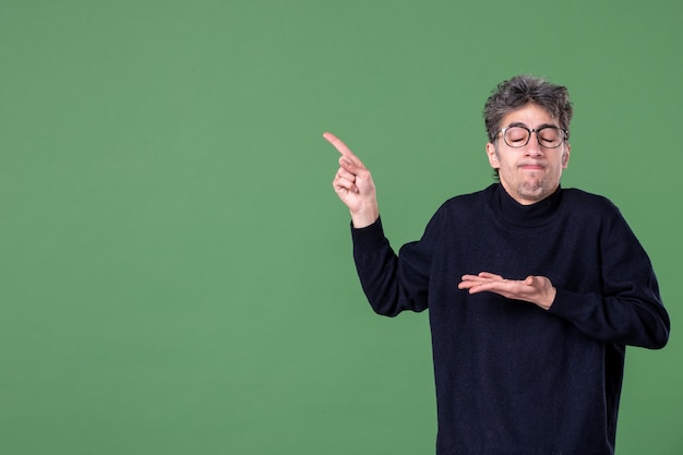 Portrait of genius man dressed casually in studio shot green surface school horizontal male color