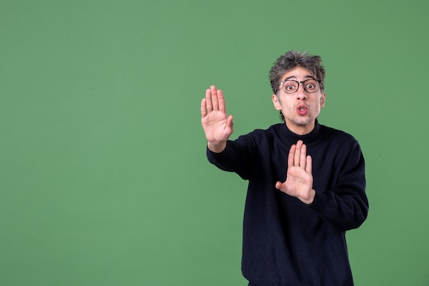 Portrait of genius man in studio shot looking at something on green wall