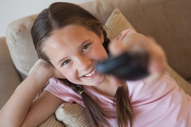 Portrait of a girl changing channels in living room