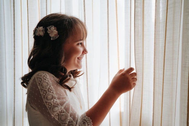 Portrait of a girl dressed in communion dress while at home