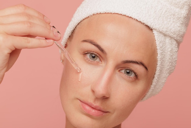 Portrait of a girl dripping oil on the skin of her face