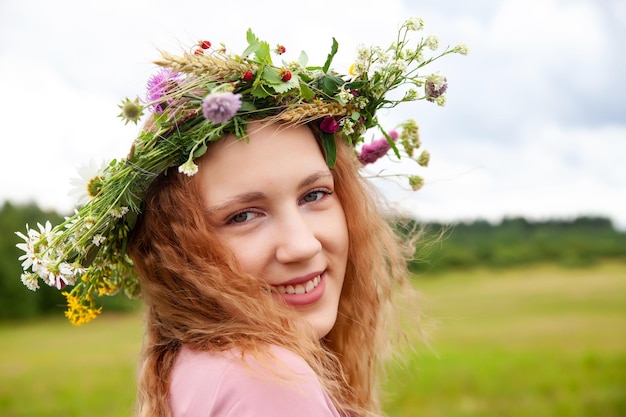 Portrait of girl in pink dress with wreath of wildflowers