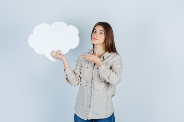 Portrait of girl showing speech bubble in shirt and looking hesitative