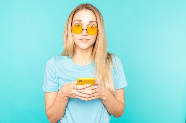 Photo portrait of girl use her smartphone read social media news scream wow omg isolated over blue color.