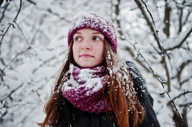 Portrait of girl at winter snowy day near snow covered trees.