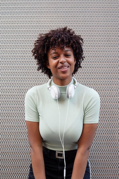 Portrait of a girl with afro hair smiling in the urban background Black girl in casual clothes