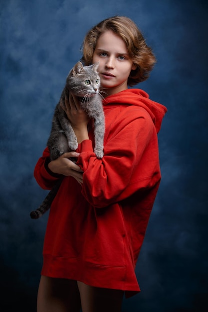 Portrait of a girl with a cat closeup on a blue background a man and an animal