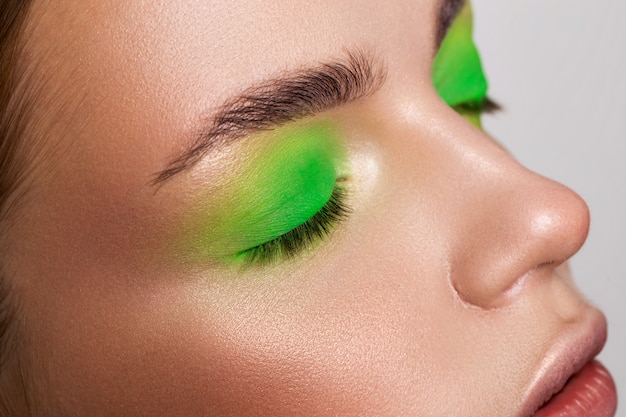 Photo portrait of a girl with a light green make-up and burgundy lips with matte lipstick.