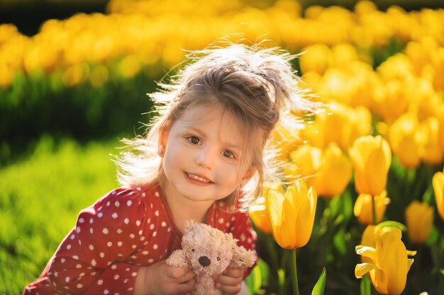 Portrait of girl with a teddy bear in her hands against the backdrop of flowers Peace in Ukraine