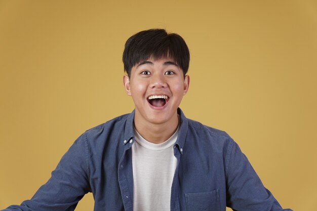 Portrait of  glad cheerful happy rejoicing excited overjoyed young asian man dressed casually isolated