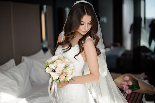 Portrait of glamour bride in elegant wedding dress,veil and bouquet