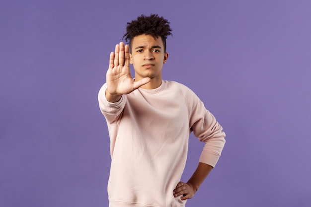 Portrait of good-looking young male student showing gesture.