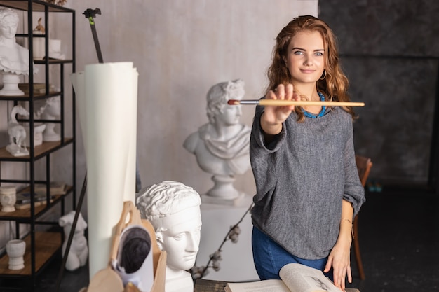 Portrait of a gorgeous female artist working on art project on her studio