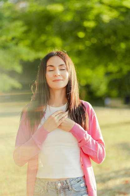 Portrait of gorgeous smiling woman with long hair posing on the street Breast cancer awareness month