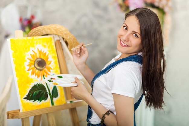 Portrait of gorgeous woman artist  painting at home