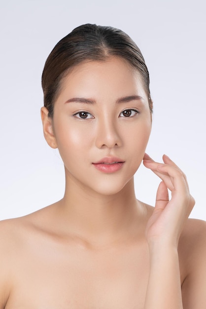 Portrait of gorgeous young girl posing beauty gesture with healthy clear skin and soft makeup Cosmetology and beauty concept