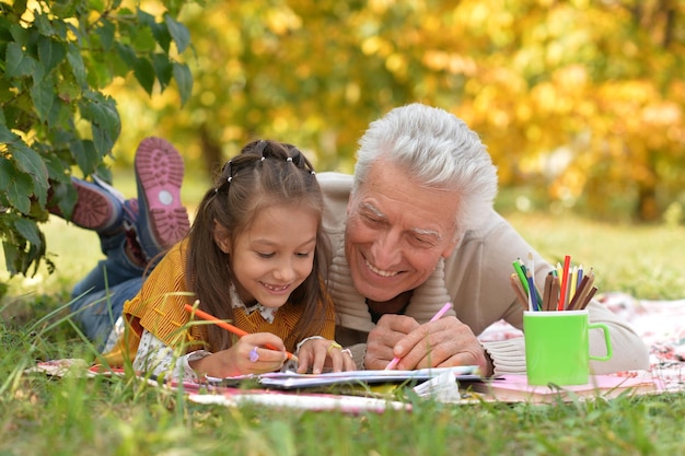 Portrait of grandfather and his granddaughter drawing