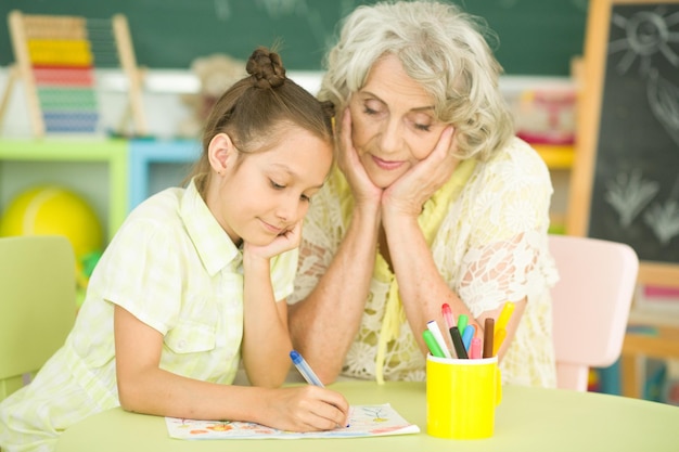 Portrait of grandmother and granddaughter drawing together