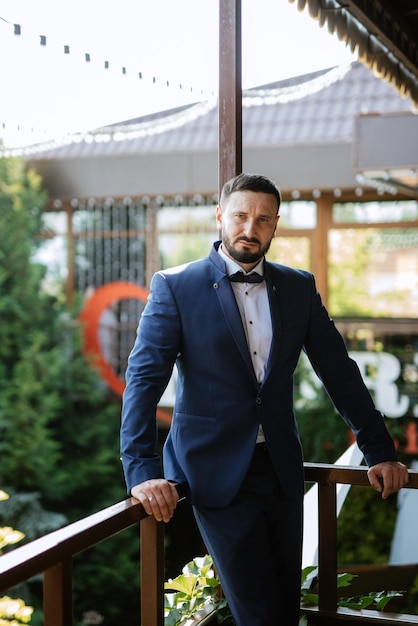 Portrait of a groom with a beard in a blue suit