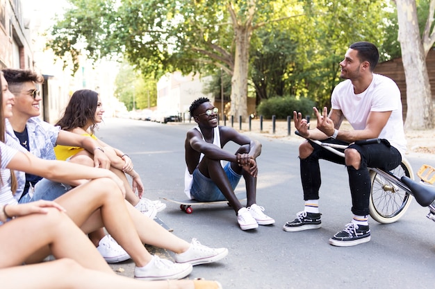 Portrait of group of young hipster friends talking in an urban area.