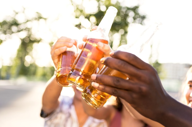 Portrait of group of young people toasting with beer in an urban area.