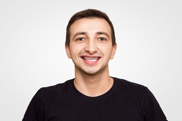 Portrait of a guy in a black t-shirt in braces