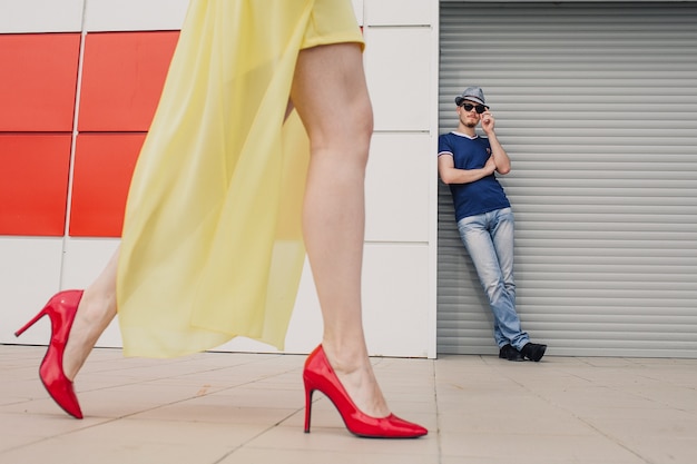 Portrait of a guy in front of a girl in red shoes