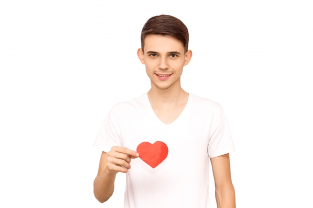 Portrait of a guy in a white t-shirt holding a heart, isolate