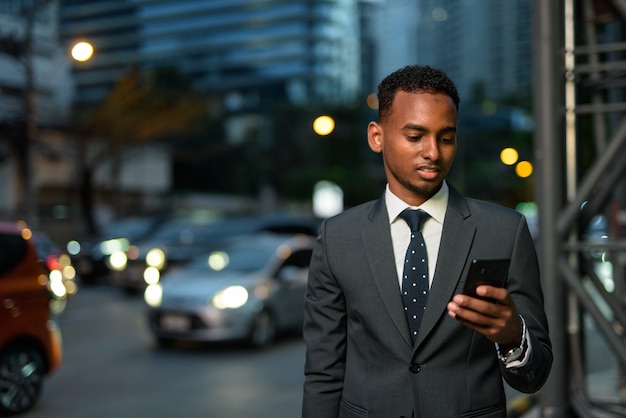 Portrait of handsome African businessman outdoors wearing suit