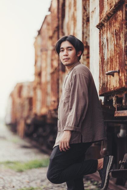 portrait of handsome asian man standing in old vintage train 