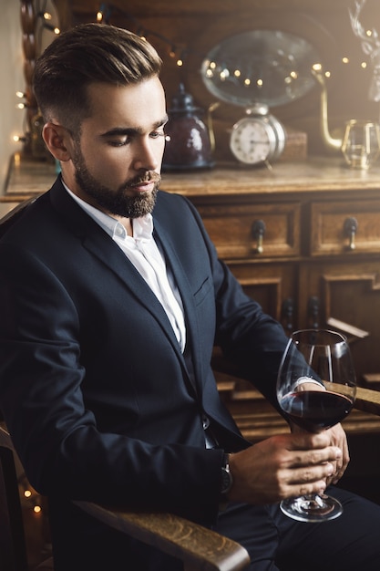 Portrait of handsome bearded man with a glass of red wine