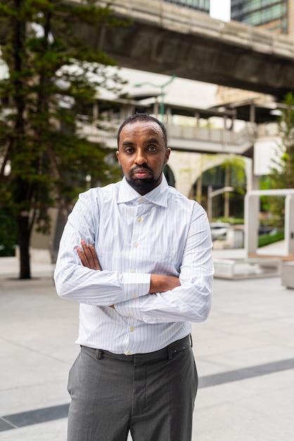 Portrait of handsome black businessman in city