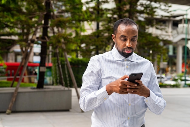 Portrait of handsome black businessman in city