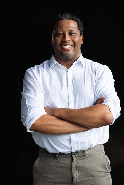 Portrait of handsome black businessman smiling with arms crossed