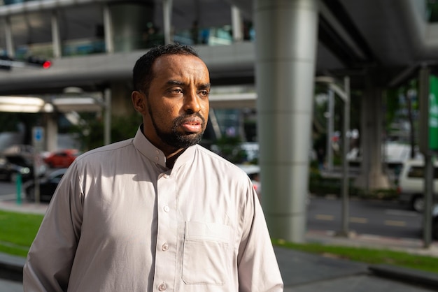 Portrait of handsome black man in city wearing traditional clothes