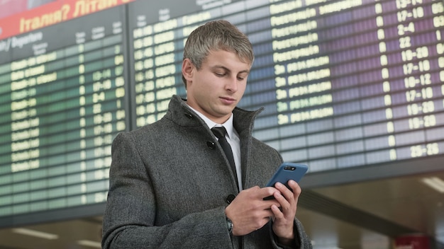 Portrait of handsome business man using smartphone.