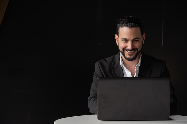 Portrait of handsome businessman using laptop computer while smiling