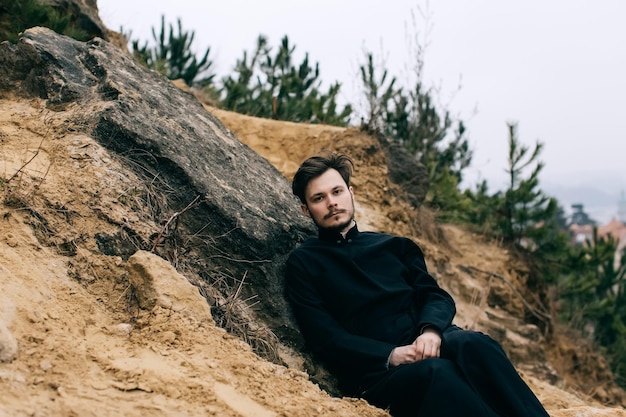 Portrait of handsome catholic bearded man priest or pastor posing outdoors in mountainsx9