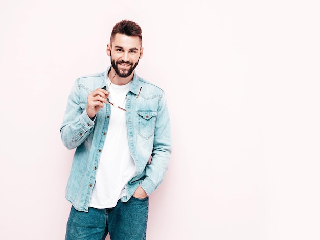 Portrait of handsome confident model Sexy stylish man Fashion hipster male posing near wall in studio Isolated